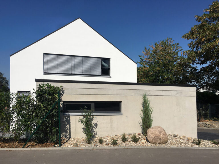 Neubau Wohnhaus in Leonberg, Vorderansicht mit modernem Design und minimalistischer Gartengestaltung.