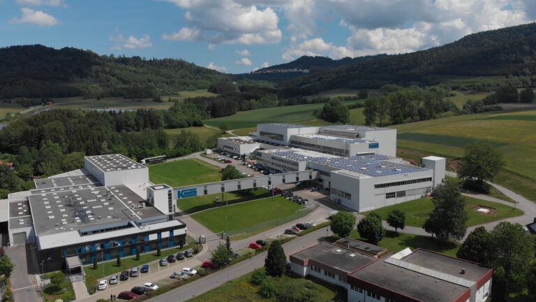 Luftaufnahme des Firmenkomplexes der Paul Kauth GmbH & Co. KG, umgeben von grünen Wiesen und Hügeln.