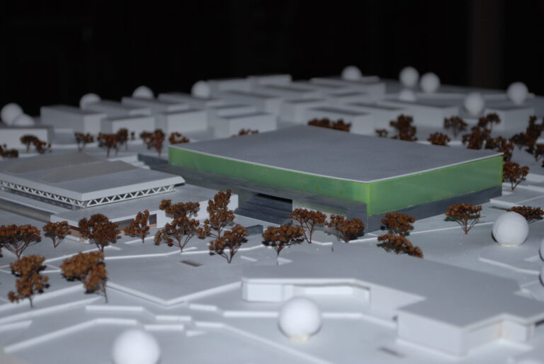 Miniaturmodell Eisstadion Ellental mit einer modernen Gebäudestruktur mit umliegenden Bäumen