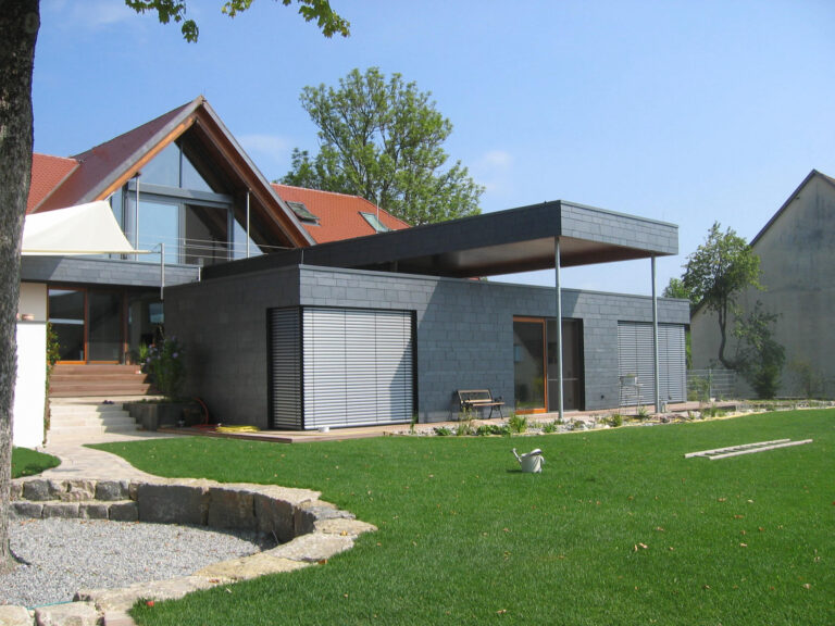 Durch Architekten gestalteter Garten mit Wohnhaus und Anbau.